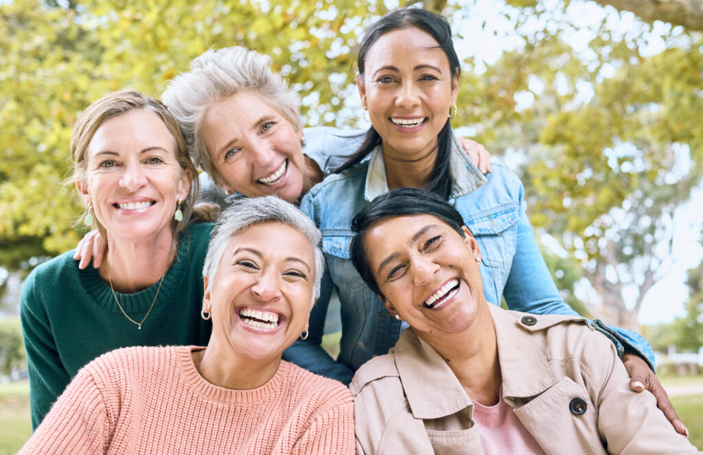 Smile, park and portrait of group of women enjoying bonding, quality time and relax in nature together. Diversity, friendship and faces of happy senior females with calm, wellness and peace outdoors. Depiction of women's health